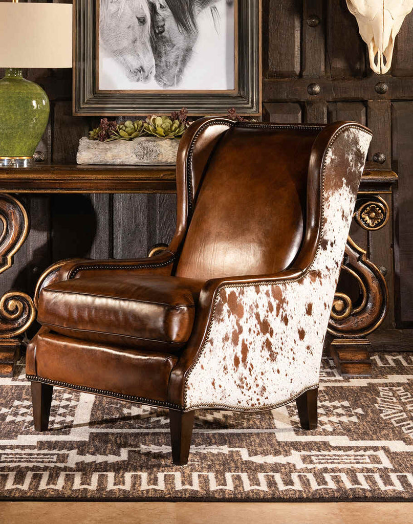 A front angled view of the Alanna Leather Chair showcasing its fine leather upholstery, brass nail tacks, and timeless wingback design.