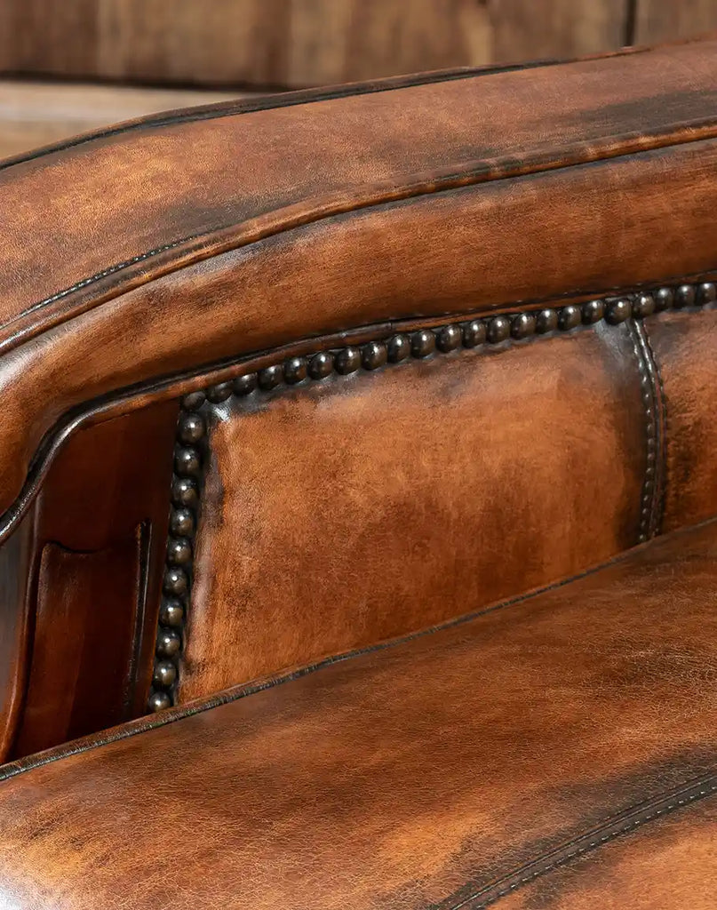 Close-up of the bronze nailhead detailing along the armrests of the recliner.