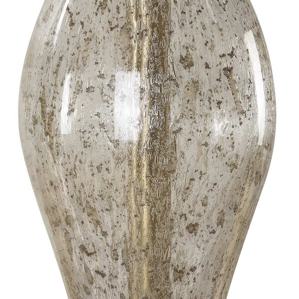 Close-up of an hourglass-shaped lamp base made of seeded glass, supported by brass-plated iron, with a sleek linen shade.