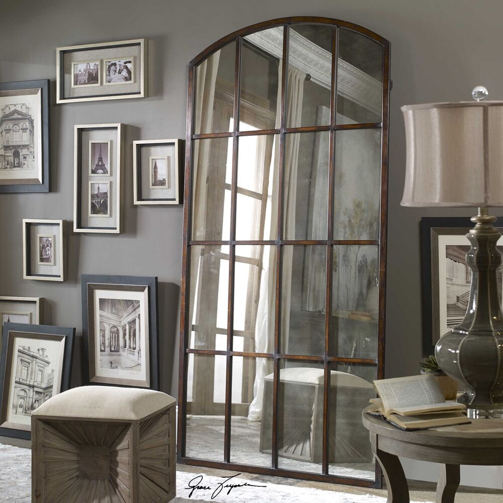 Antique-style arched mirror with a grid panel design, crafted with a rustic bronze frame and weathered glass panels.