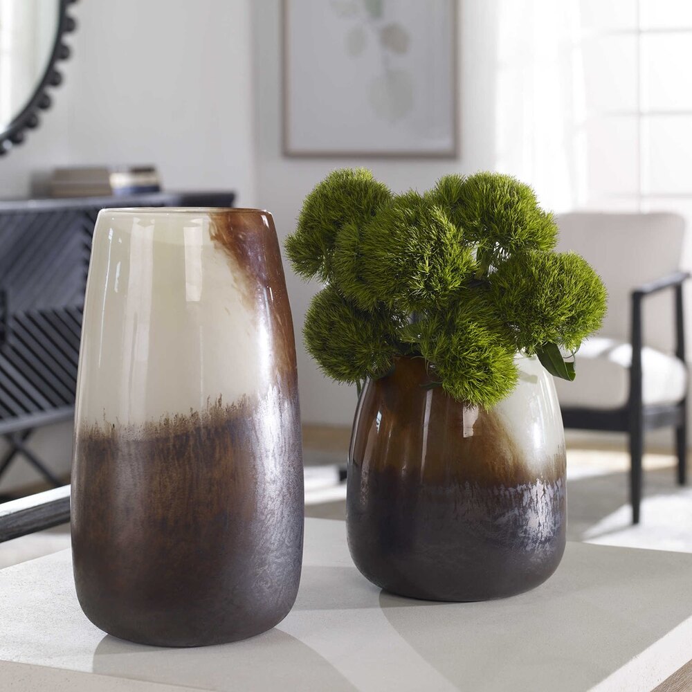 Handcrafted glass vases in earthy hues of pale sand, rust, and bronze, perfect for enhancing floral arrangements or candle displays.