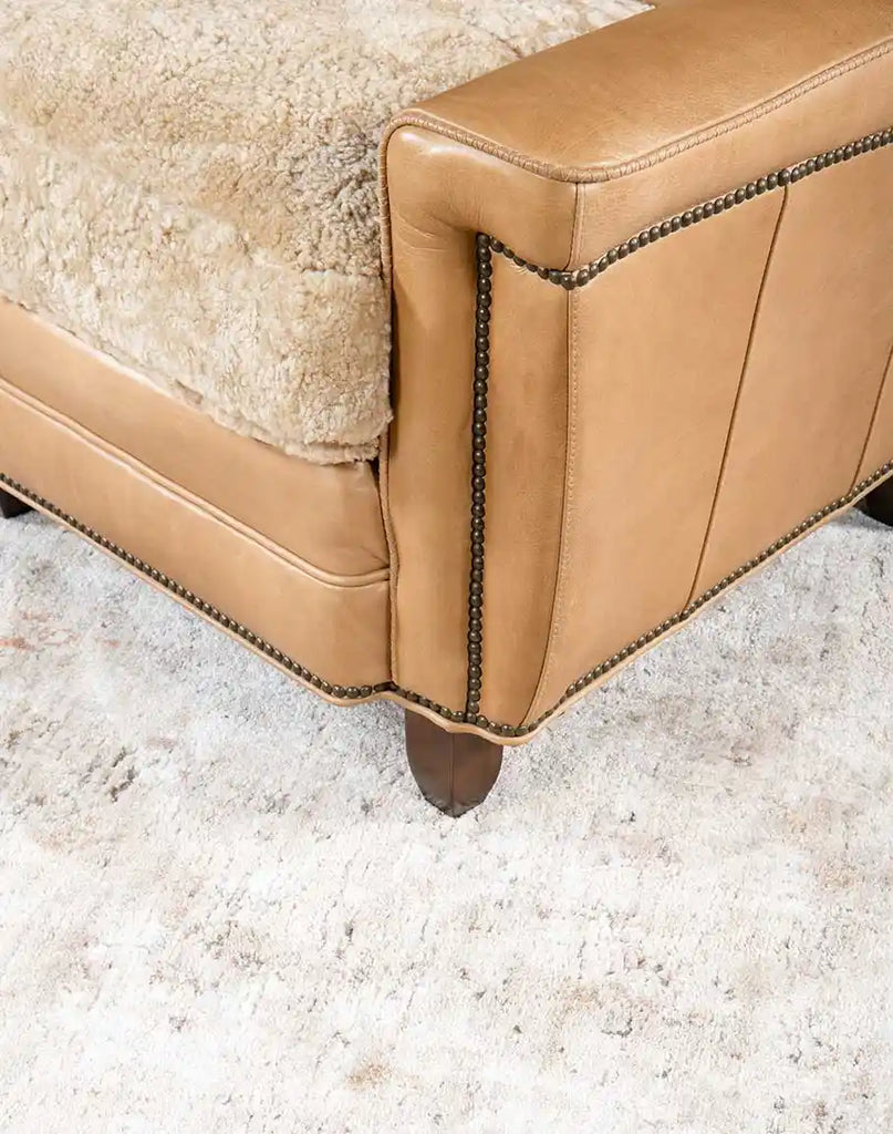 The armrest of the Beige Sand Club Chair, showcasing the soft hand-burnished leather and precise stitching.