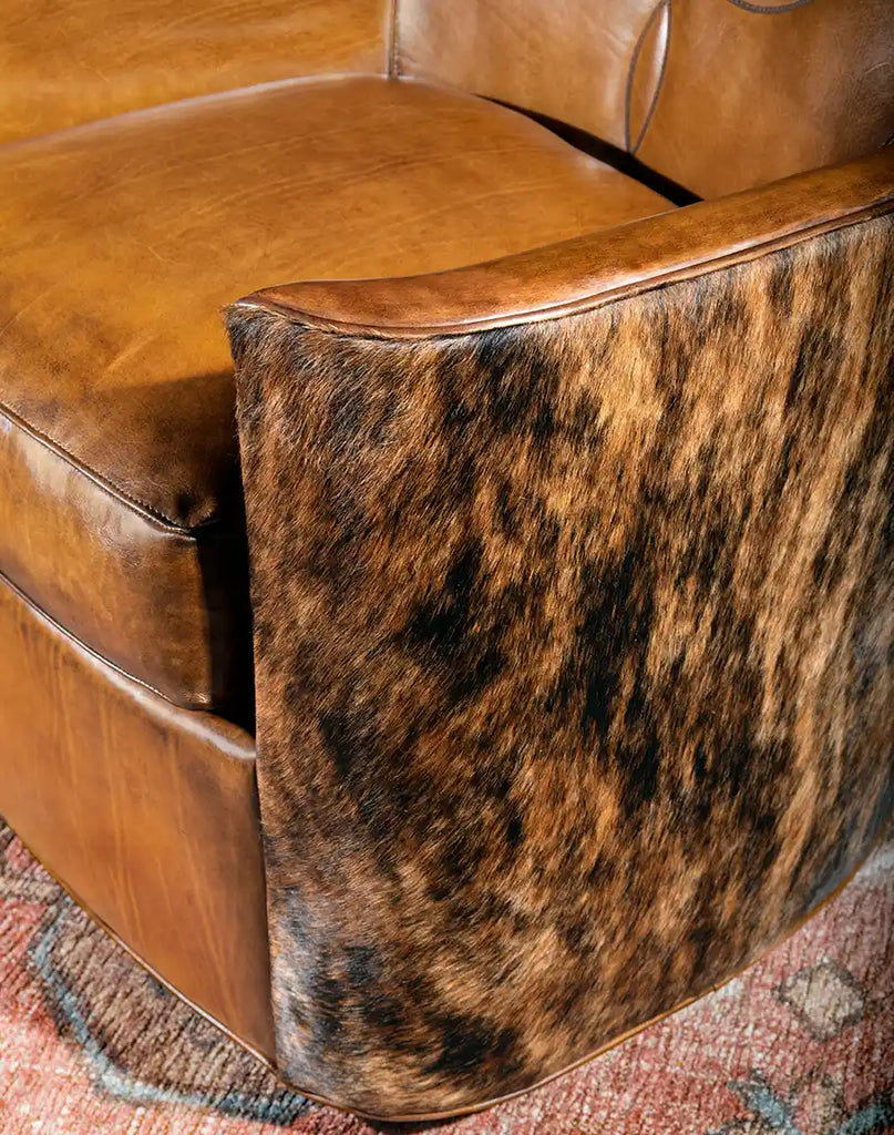 Close-up of the Bourbon Barrel Swivel Chair's thick leather armrests with hand-burnished accents.