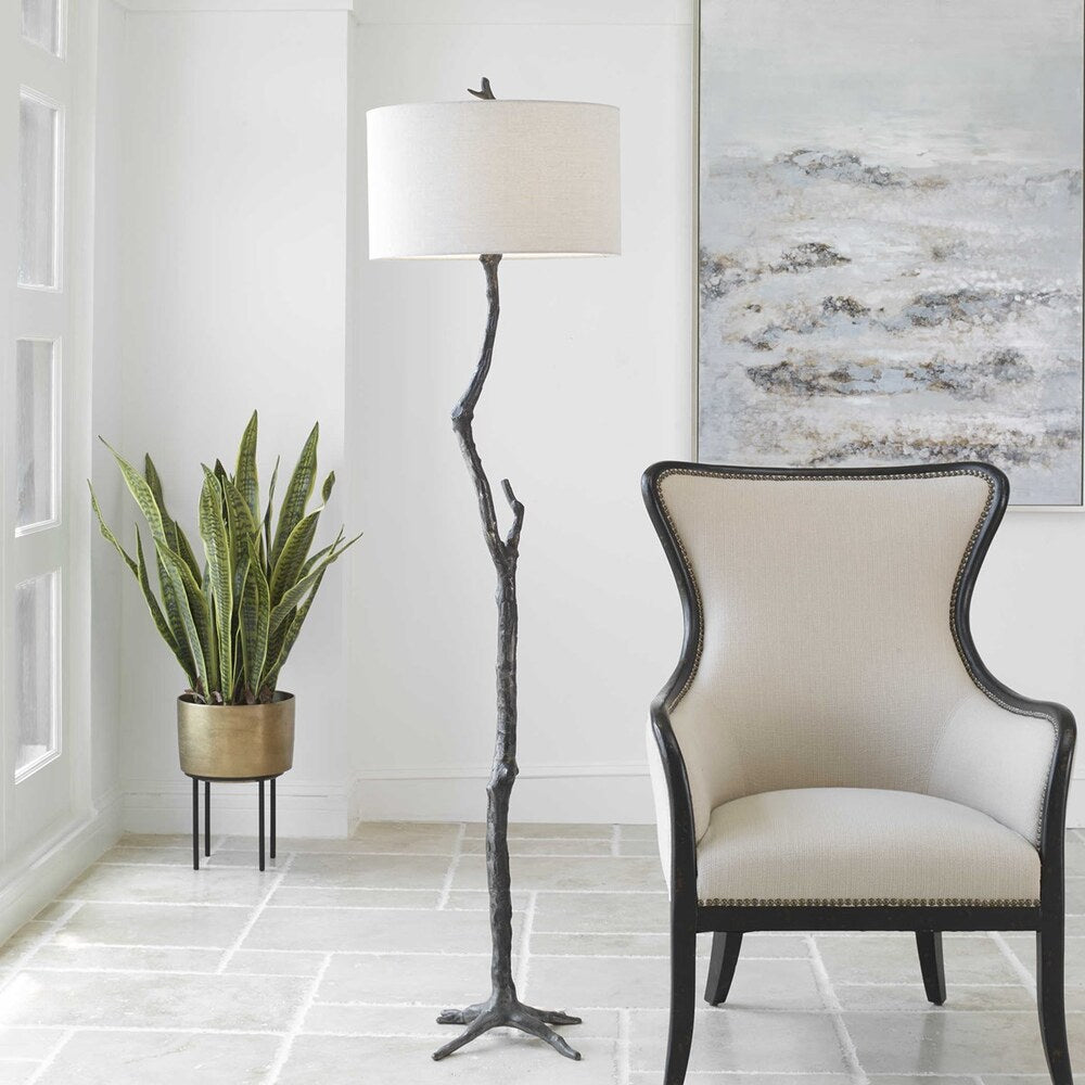 Nature-inspired floor lamp crafted from cast iron, showcasing intricate sculpted details and a drum-shaped gray linen shade.