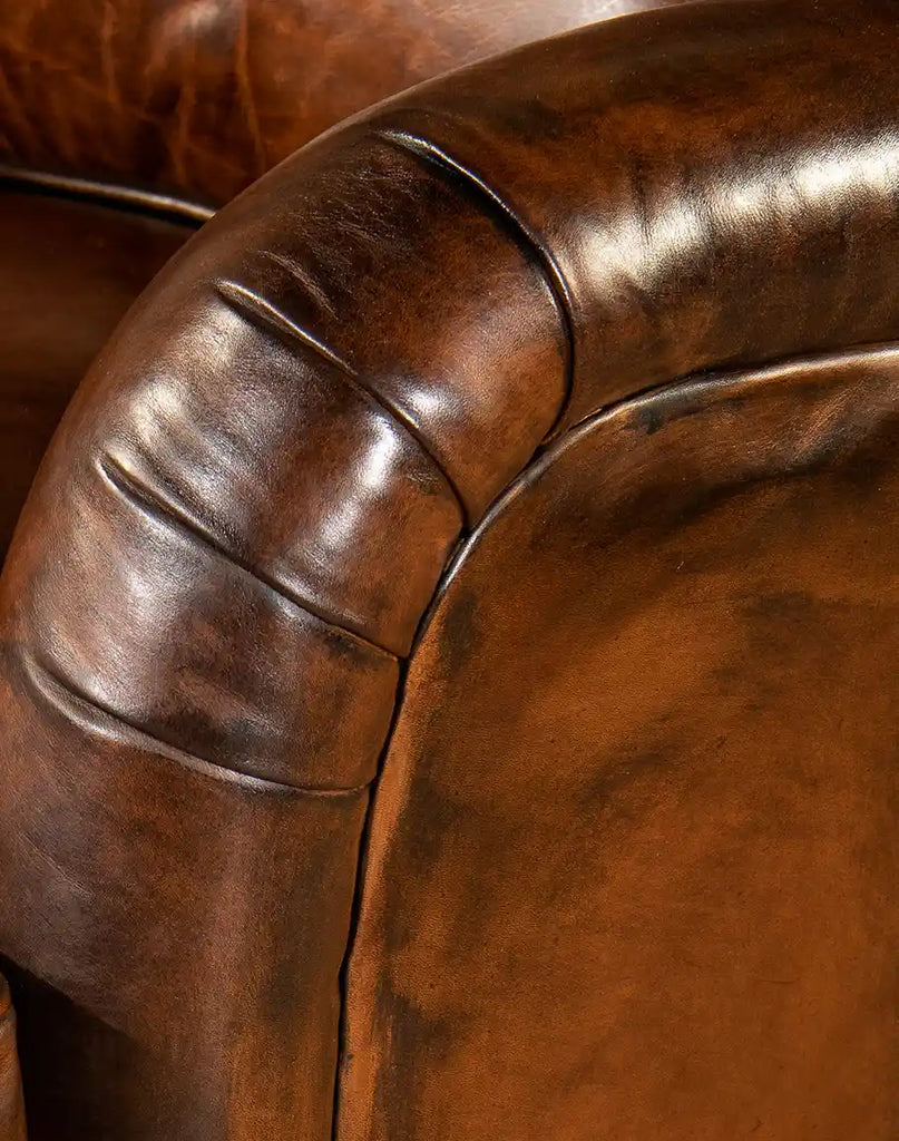 Close-up of the hand-burnished leather armrests on the Brono Swivel Glider Chair, showcasing its rustic elegance.