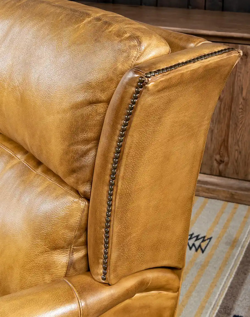 Close-up of the bronze nailhead trim against the deep leather tones of the St. Lauriat Recliner.