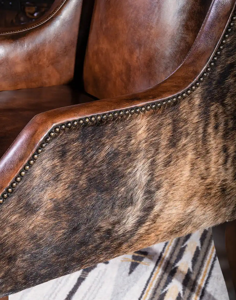 A close-up view of the curved armrests on the Cantina Leather Chair, wrapped in premium leather with decorative stitching.