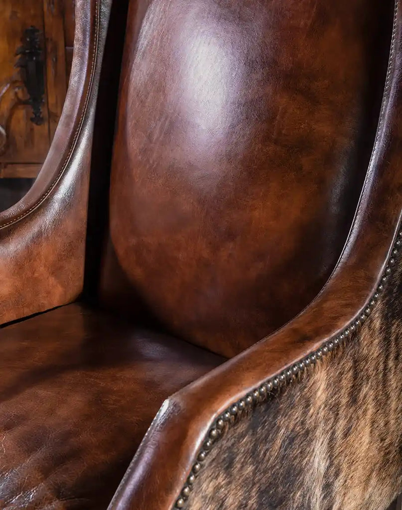 A detailed close-up of the full-grain leather texture on the Cantina Leather Chair, highlighting its natural grain and hand-burnished finish.