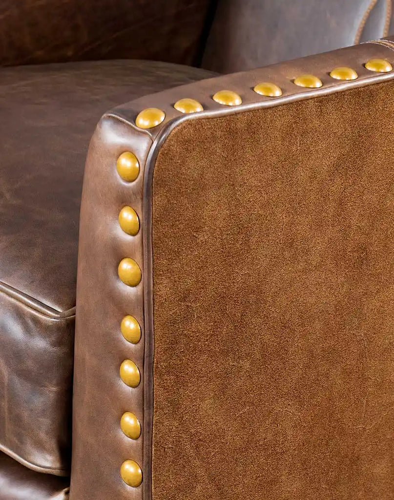 Close-up of the brass nailhead trim outlining the Cassie Brown Leather Chair's arms and base.