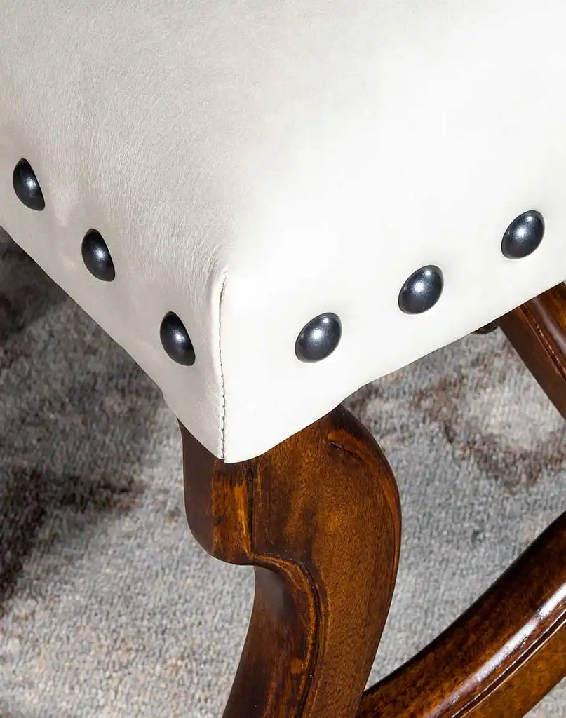 Detailed image focusing on the brass stud accents along the edges of the chair's frame.