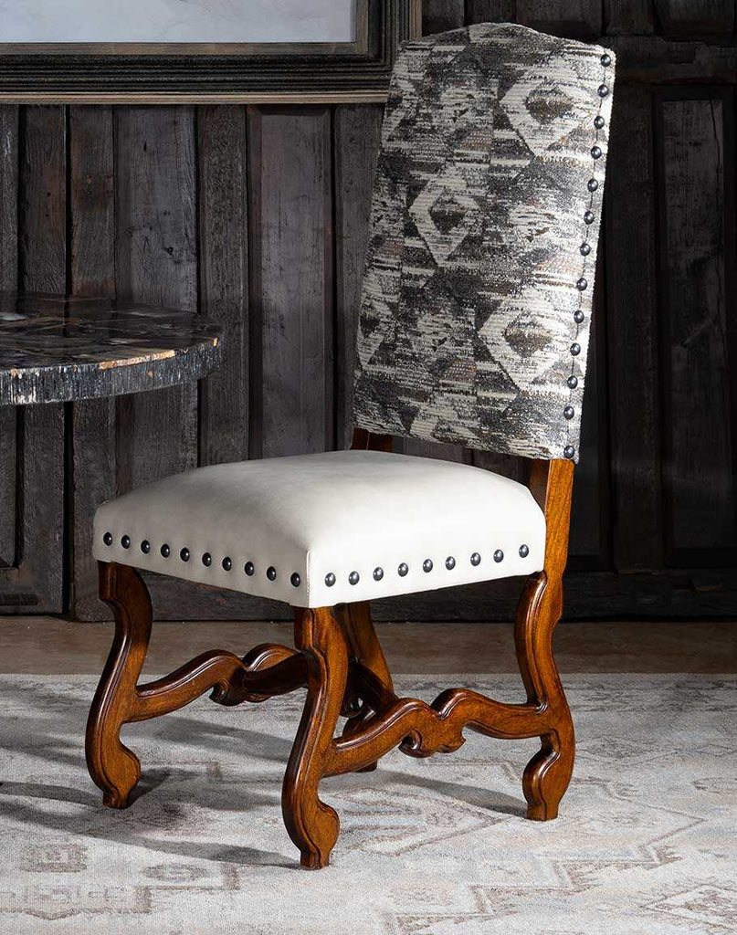 Front perspective showcasing the chair's unique patterned fabric backrest and cream leather seat.