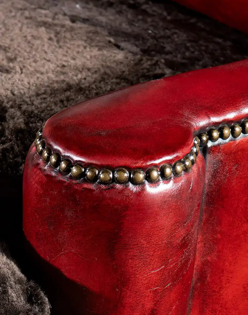 Detailed view of the Cherry Red Leather Chair’s armrest, showcasing the intricate craftsmanship and high-quality leather finish.