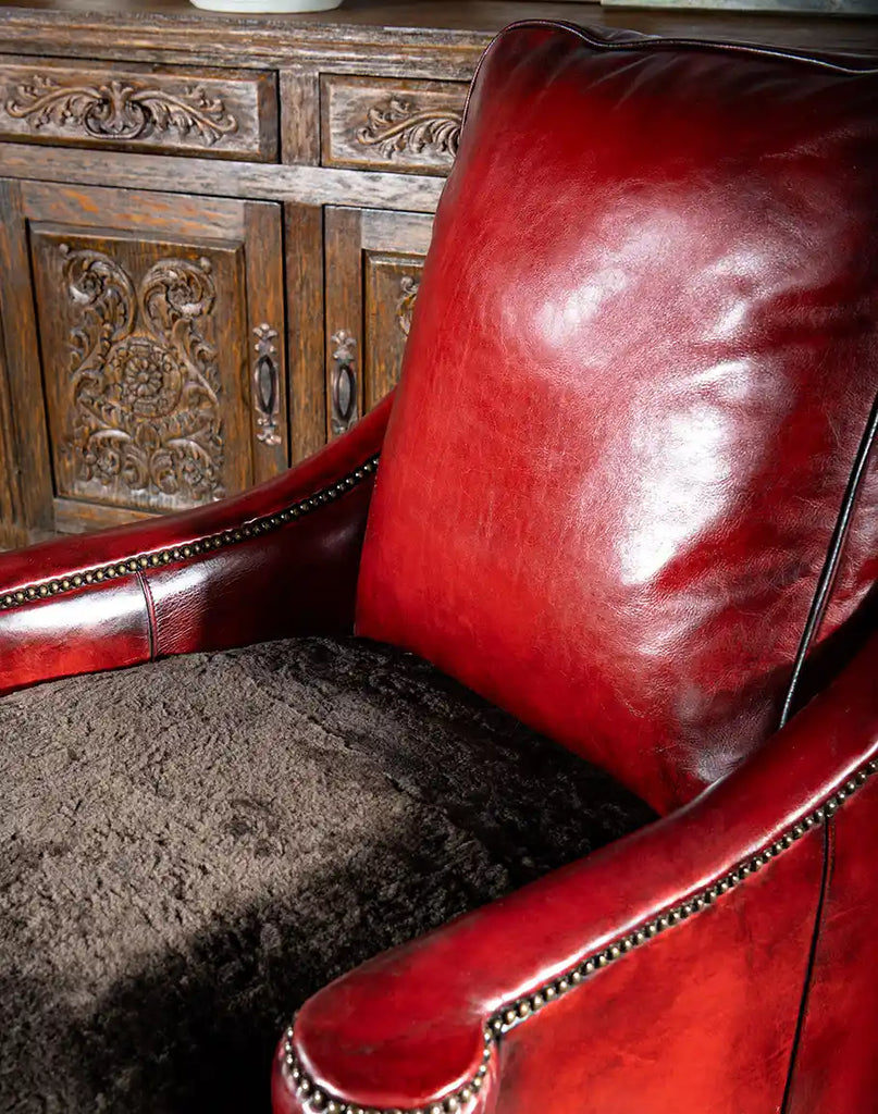 Close-up of the Cherry Red Leather Chair’s seat cushion, upholstered in genuine chocolate shearling for added softness and elegance.