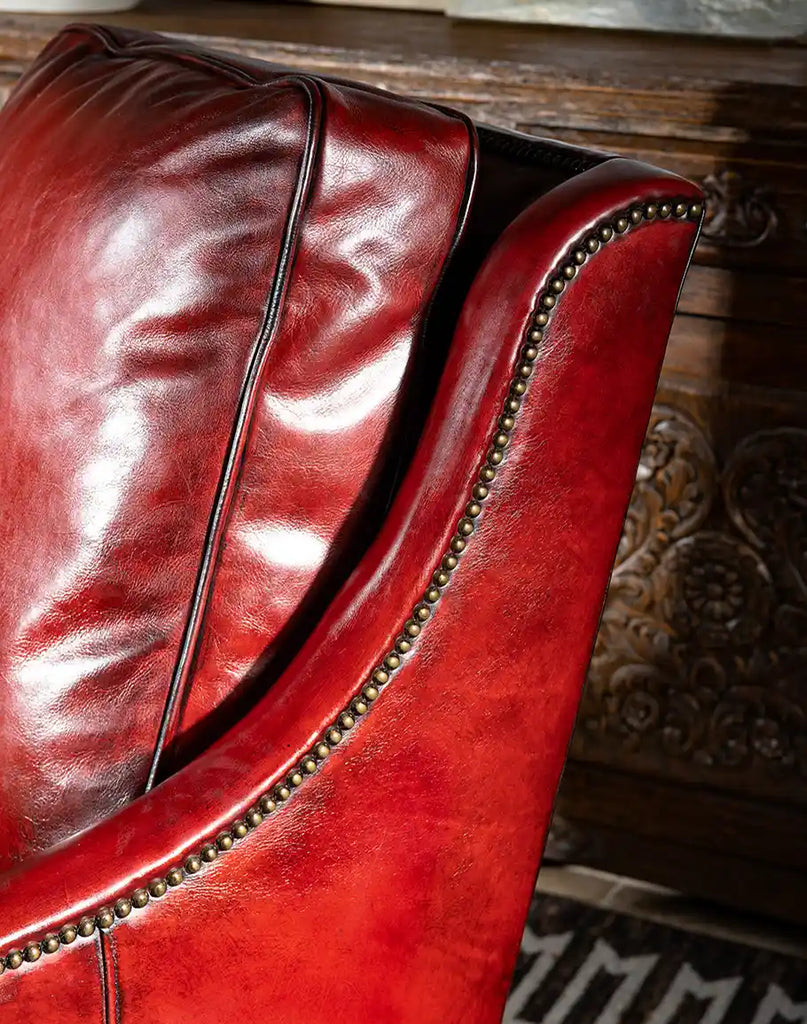 A close-up shot of the Cherry Red Leather Chair’s rich, distressed red leather with natural variations in tone and texture.