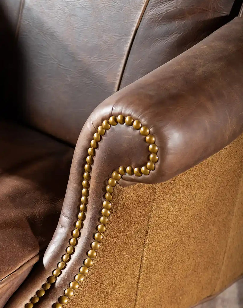 Close-up of the armrest on the Chestnut Brown True Grit Executive Desk Chair featuring full-grain brown leather and brass nail tacks.