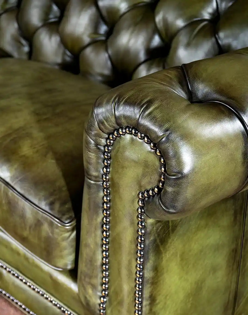 Focus on the iconic rolled arms and deep button tufting of the Evergreen Chesterfield Sofa.