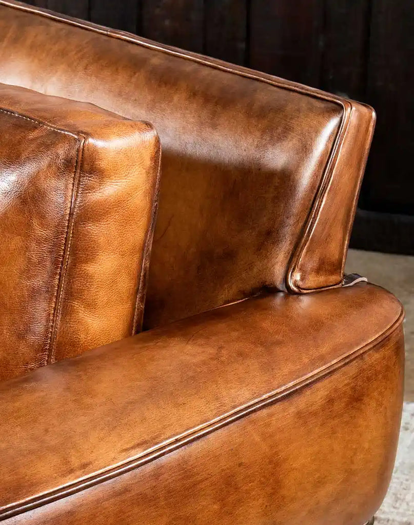 Close-up image showcasing the rich, hand-burnished leather texture of the Herdsman Western Leather Sofa.