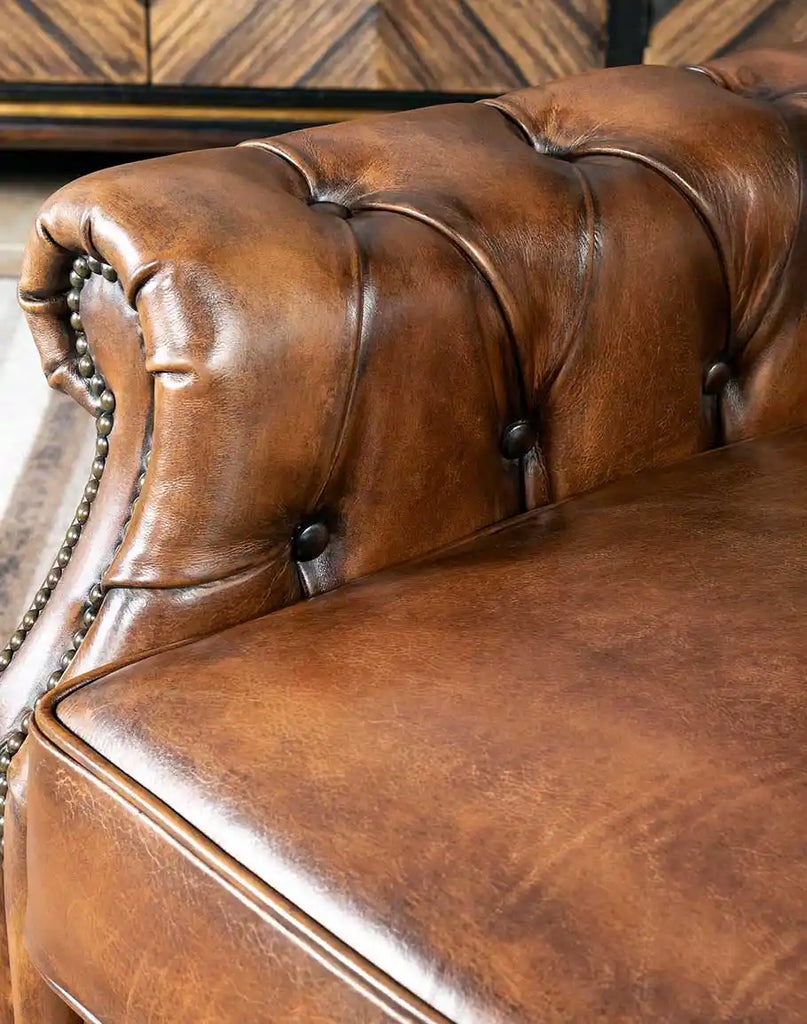 Detailed shot of the padded armrests, showing the rich texture of the hand-burnished full-grain leather.