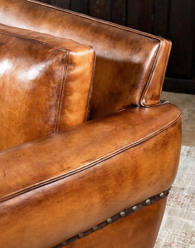 Close-up image illustrating the natural aged patina developing on the hand-burnished leather of the Herdsman Sofa.