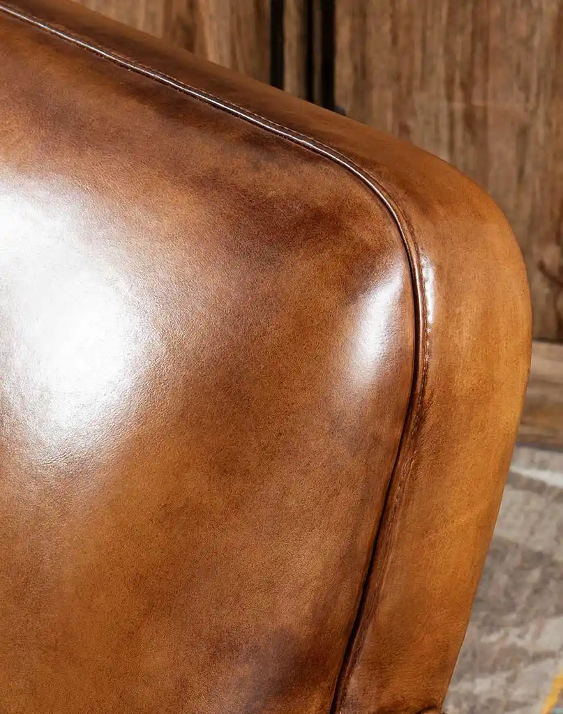 A detailed close-up of the pleated leather backrest of the Yeager Swivel Chair, emphasizing its meticulous stitching.