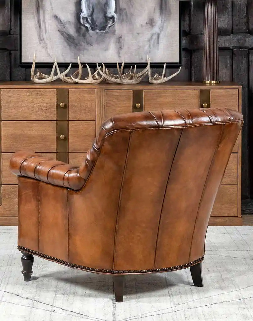 Detailed view of the rounded back and tufted leather of the Victorian-inspired chair.