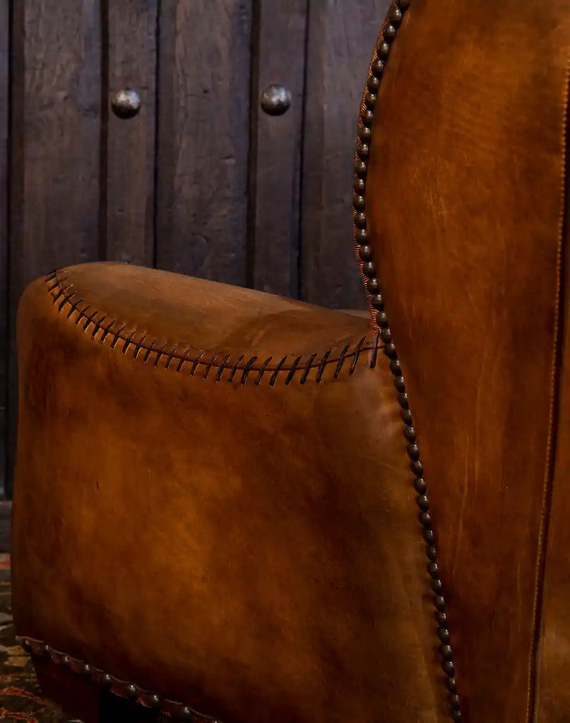 Detailed view of the whip-stitched leather arms and brass nailhead trim on the Farmhouse Ranch Chair, showcasing its rustic craftsmanship and elegance.