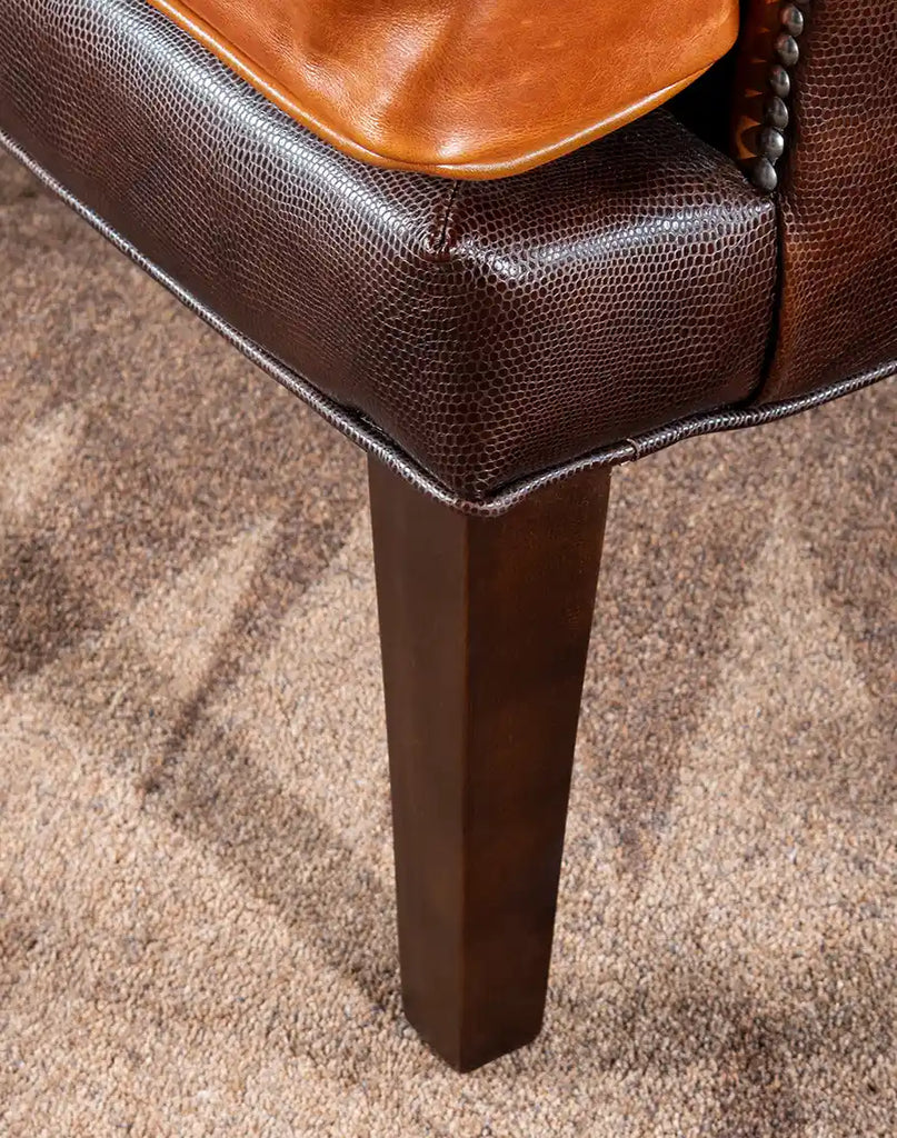 A view of the chair’s solid wood legs, featuring a deep finish that complements the leather upholstery.