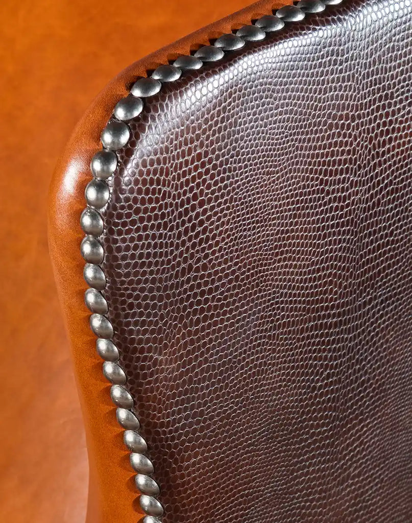 A side profile shot of the Cognac Leather Chair, showcasing its wingback structure and refined silhouette.