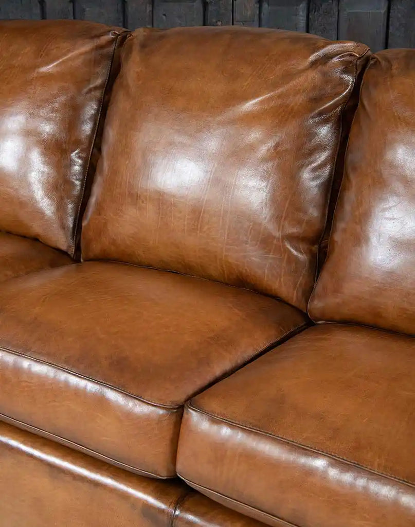 Close-up of the developing patina on the hand-burnished leather of the Colorado Leather Sofa, enhancing its timeless beauty.