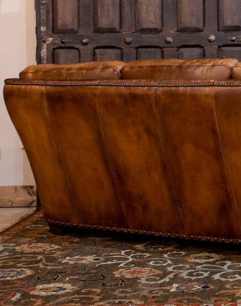 The back view of the Cowboy Leather Sofa showcasing its sleek leather upholstery and fine stitching details, ensuring style from every angle.