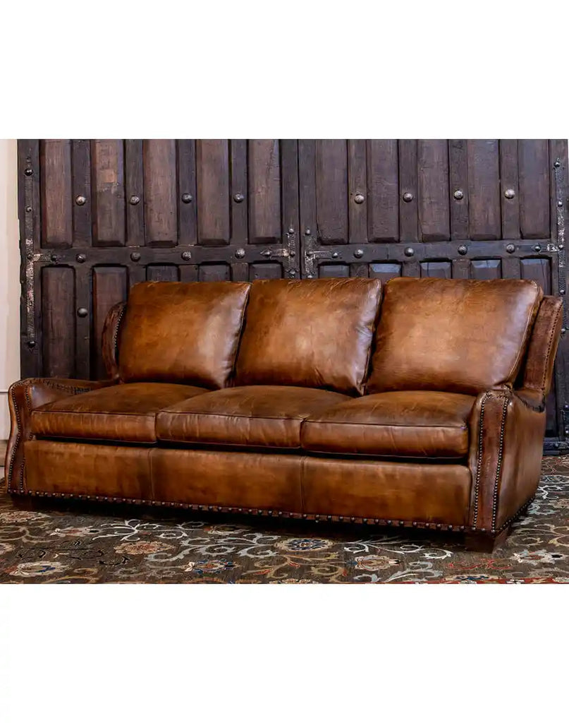 Side angle of the Cowboy Leather Sofa highlighting its whip-stitched arm design and rustic yet modern appeal.