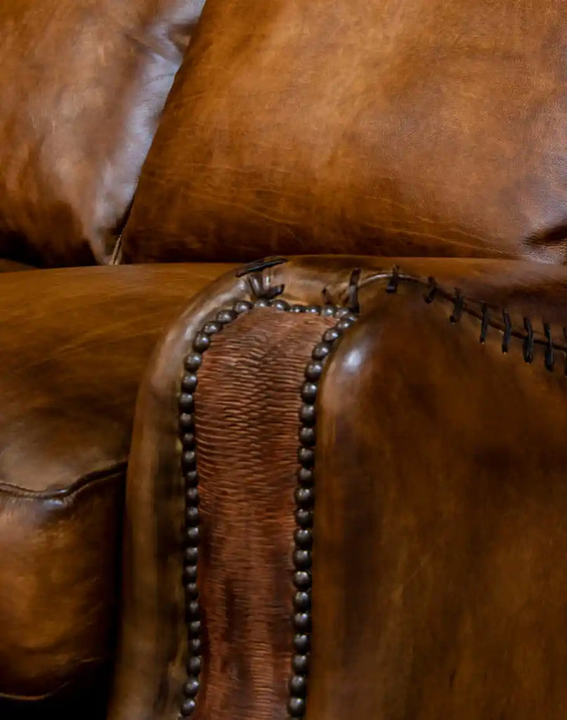 A close-up of the whip-stitched armrests on the Cowboy Leather Sofa, demonstrating its meticulous hand-crafted design.