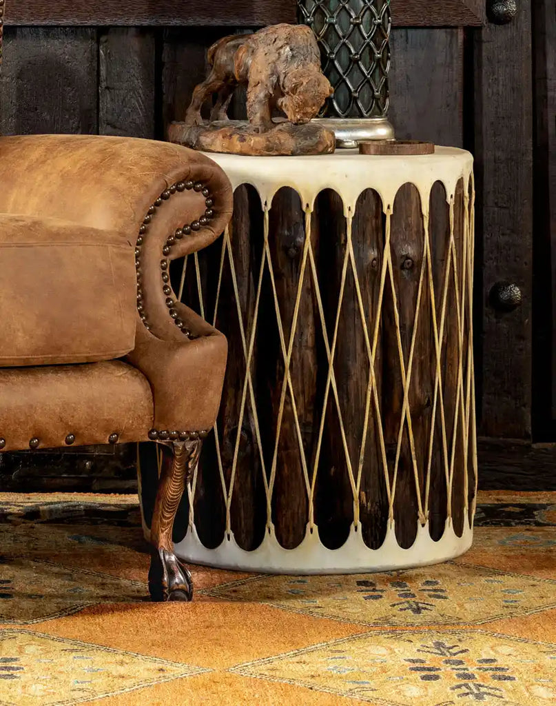 The Cylinder Accent Table styled in a modern living room, paired with a cozy armchair and decorative elements for a refined look.