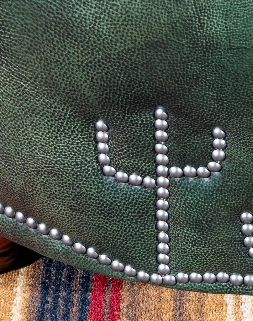 A detailed close-up of the decorative nailhead trim on the Dark Green Cacti Ottoman, adding a touch of sophistication to its design.