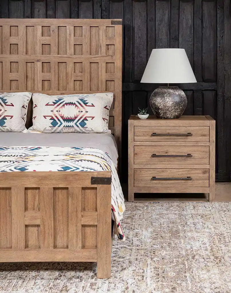 The Desert Sand Triple Drawer Nightstand styled next to the Sierra Sand Bed in a rustic bedroom, creating a cohesive and elegant look.