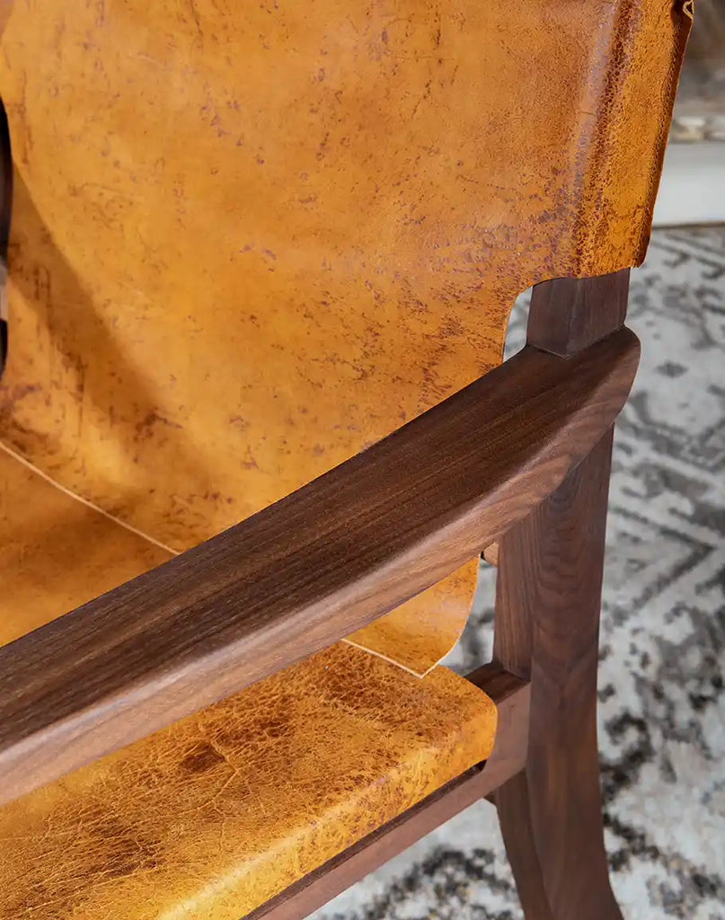 Close-up shot of the armrest detailing, showcasing the seamless connection between leather and wood.