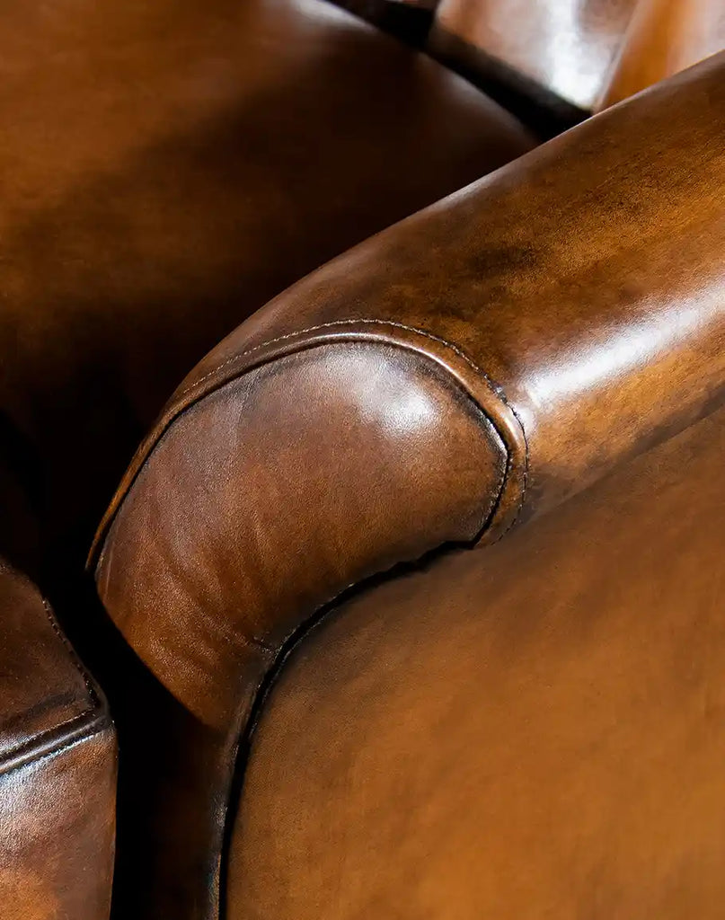 Detailed image focusing on the armrest, highlighting the fine stitching and hand-burnished leather of the Donna Tufted Swivel Chair.