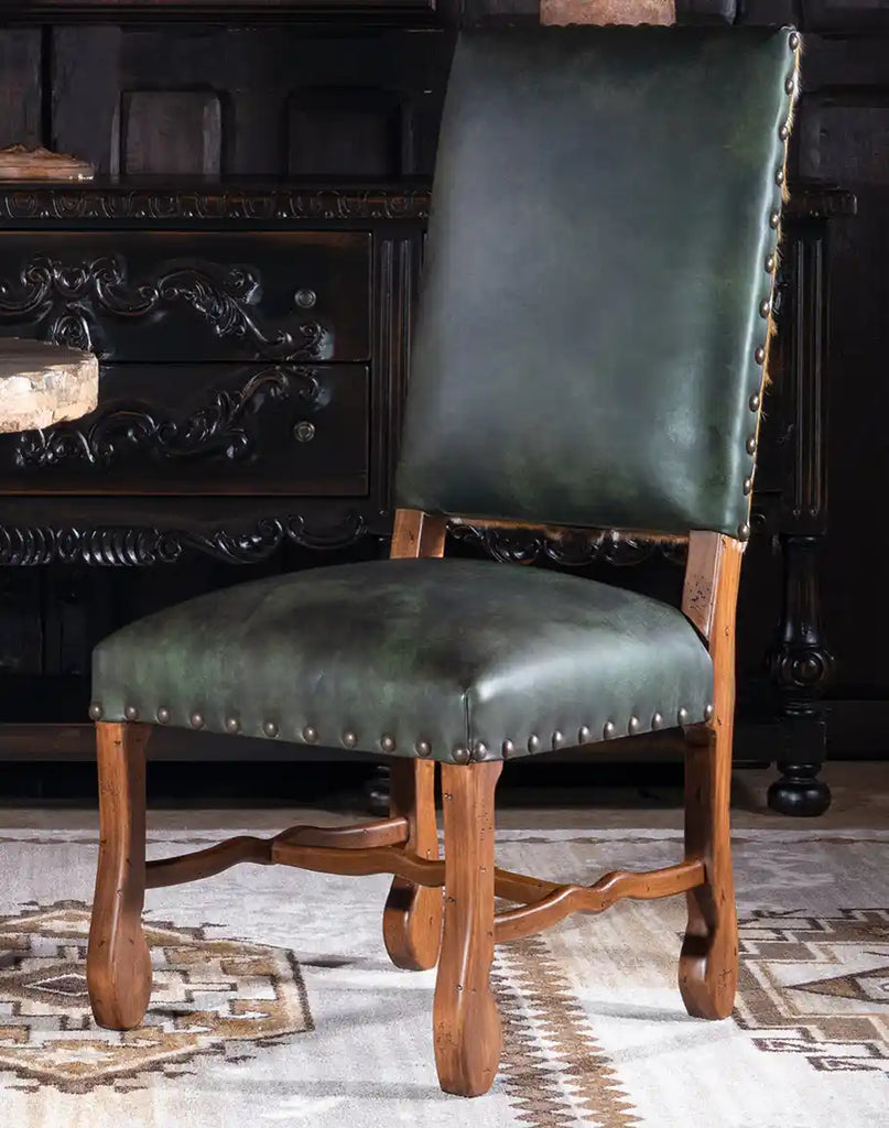 A side profile of the Forest Green Saguaro Leather Dining Chair, showcasing its sleek silhouette and artisanal design.