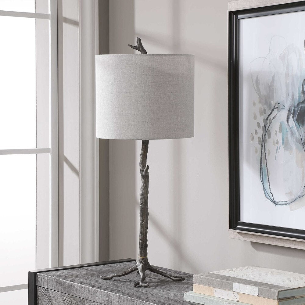 Elegant table lamp featuring an organic base in gunmetal or antique gold finish with a slubbed linen drum shade.