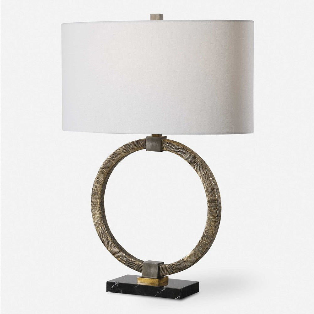 Hand-carved gold table lamp featuring intricate tribal patterns, bold bronze accents, and a classic white linen oval shade.