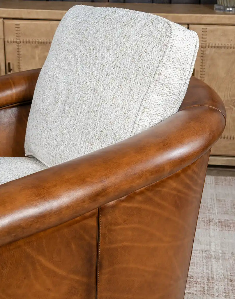 Angled view of the Elsa Bark Swivel Chair highlighting the hand-burnished leather accents and elegant design.