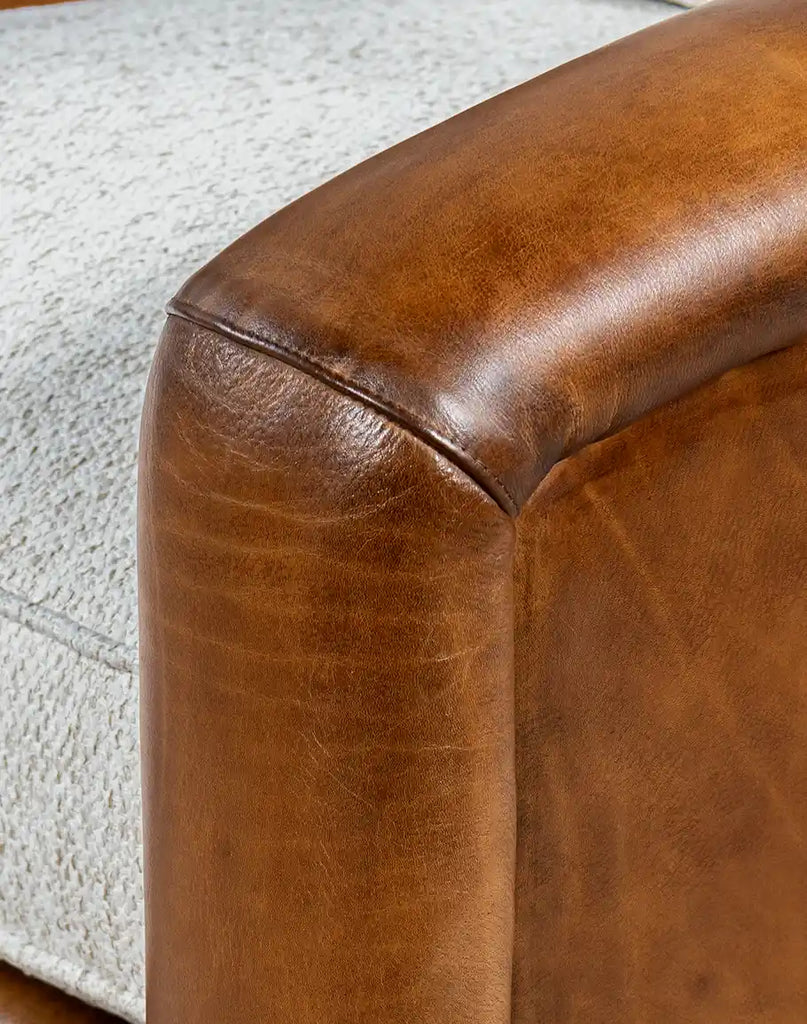 Close-up of the Elsa Bark Swivel Chair's hand-burnished full-grain leather, highlighting its rich texture and natural finish.