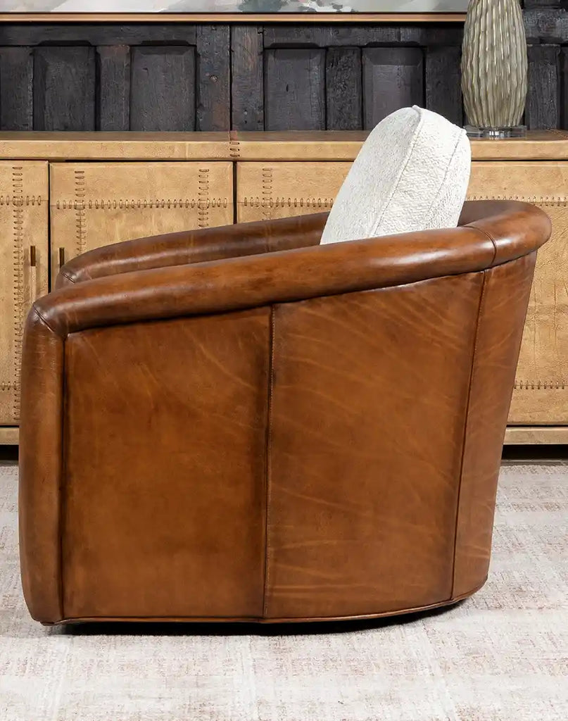 Side profile of the Elsa Bark Swivel Chair, emphasizing the seamless blend of leather and tweed fabric.