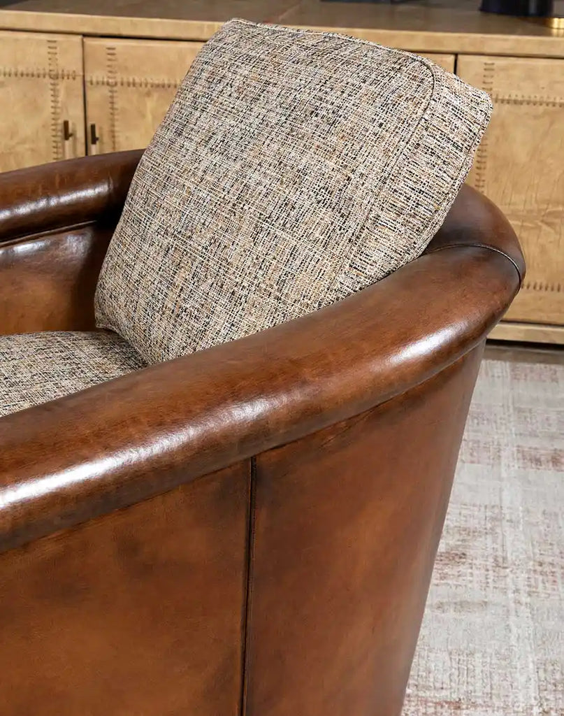 Angled view of the Elsa Cocoa Swivel Chair highlighting its sleek design and combination of full-grain leather and soft tweed fabric.