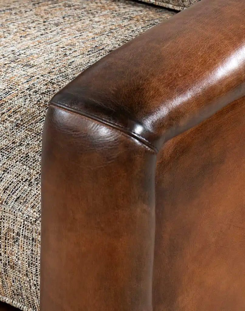 Close-up image capturing the rich texture and hand-burnished details of the Elsa Cocoa Swivel Chair's full-grain leather exterior.