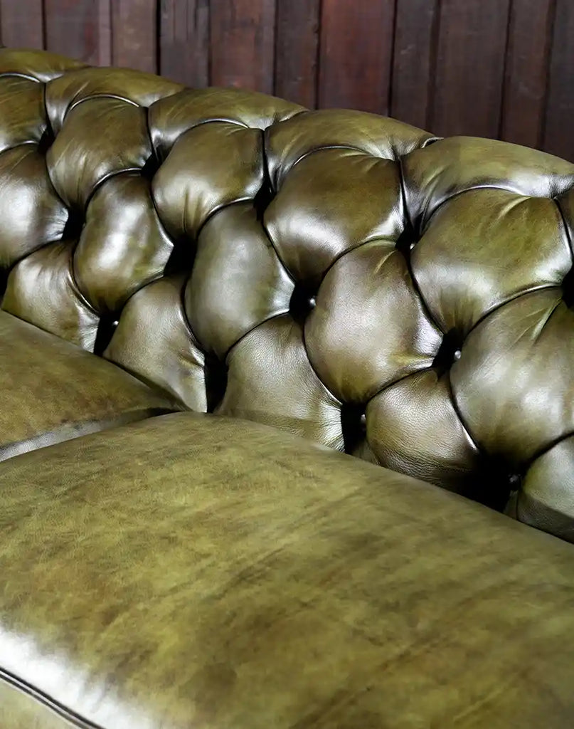 Close-up of the plush seat cushions and deep button tufting of the Evergreen Chesterfield Sofa.