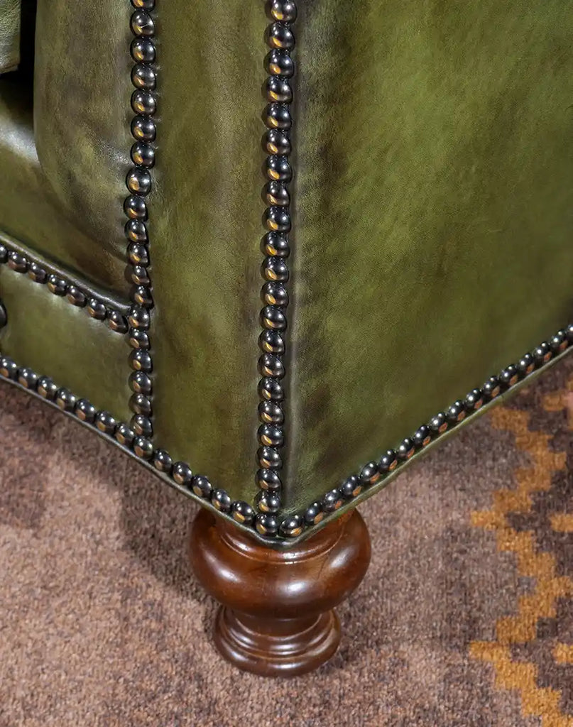 Detailed close-up of the Evergreen Chesterfield Sofa's elegantly crafted wooden leg, showcasing its sturdy build and refined finish.