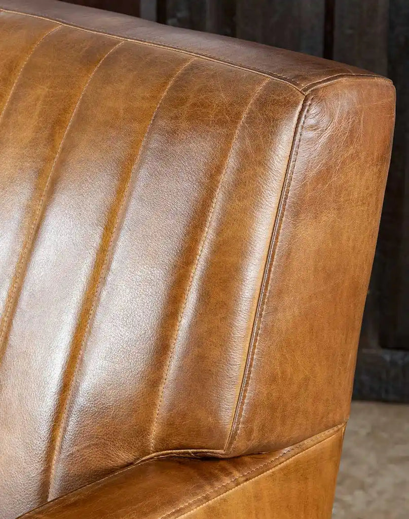 Close-up image capturing the hand-burnished full-grain leather texture of the Fox Saddle Leather Sofa in a warm saddle tan color.