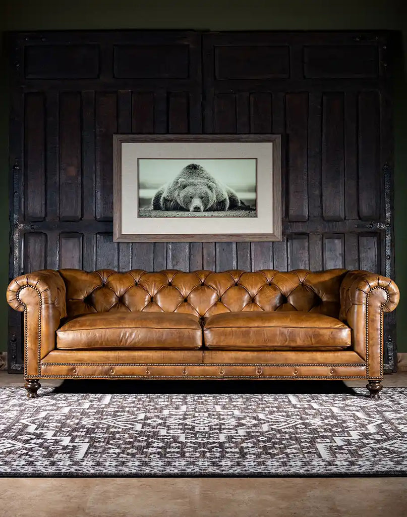 A front view of the Nova Chesterfield Sofa showcasing hand-burnished leather, deep tufting, and brass nailhead accents.