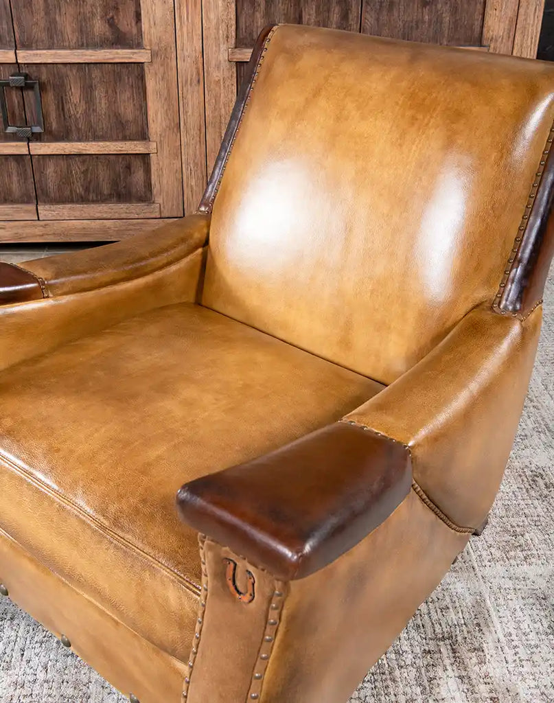 A close-up of the Lucy Leather Chair highlighting its elegant horseshoe detail.